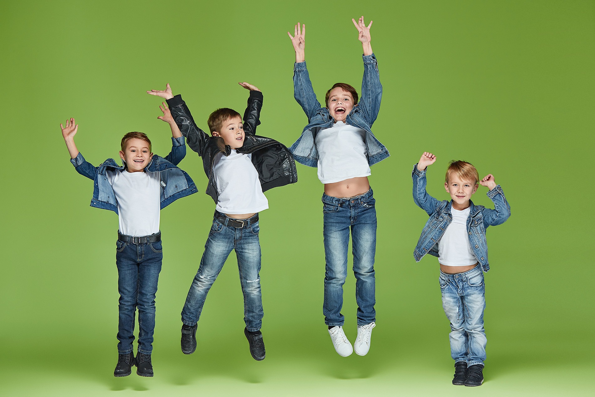 Fünf Kinder jubeln mit erhobenen Armen vor grünem Hintergrund – Freude und Gruppendynamik durch Tanz.