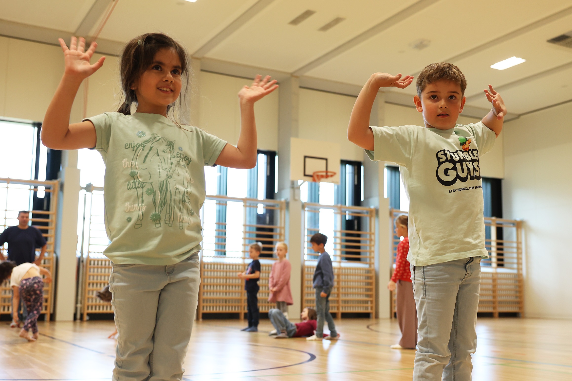 Lehrkraft führt Kinder im Tanzunterricht Kinder tanzen in zwei Reihen im Soul-Train-Stil und entdecken mit groove2grow die Freude an Bewegung