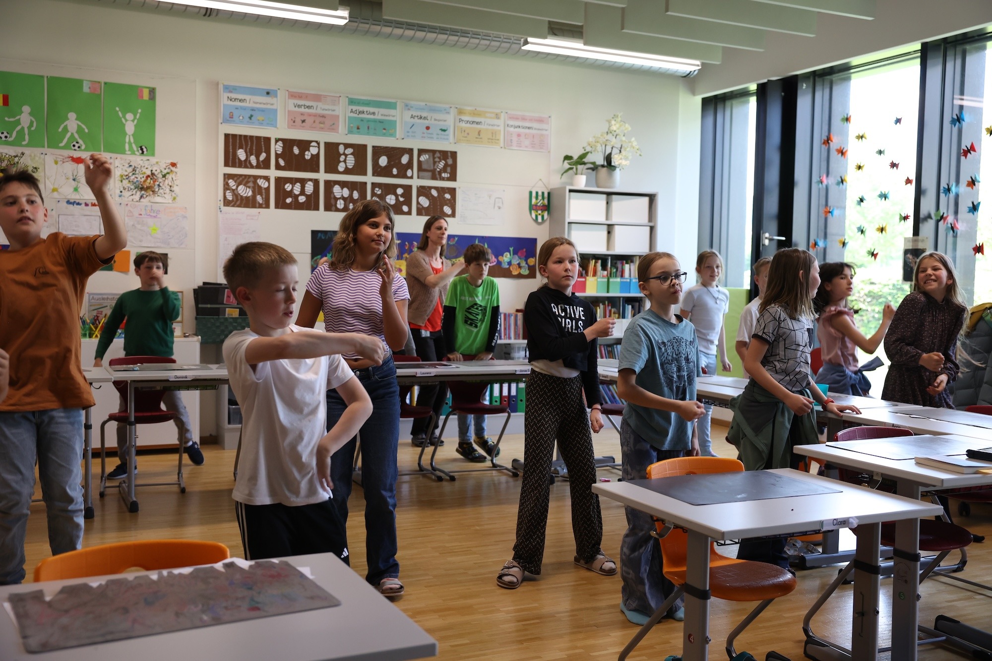 Evolution Dance Freude an Bewegung: Grundschulkinder und Lehrkraft üben gemeinsam Tanzschritte im Unterricht.