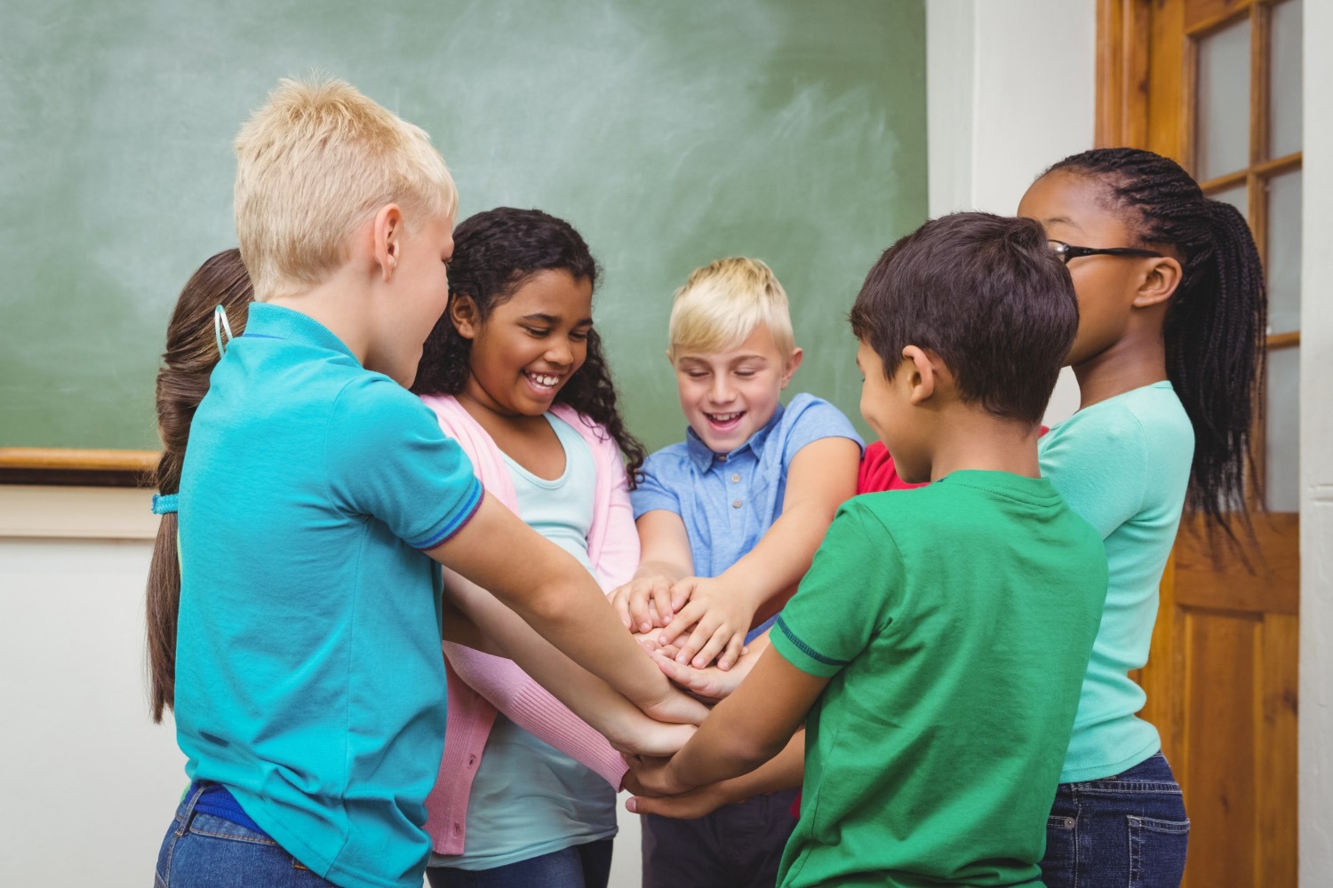 ine Gruppe aufgeregter Grundschulkinder rennt und tanzt spontan in schneller Bewegung in einem hellen Schulflur.